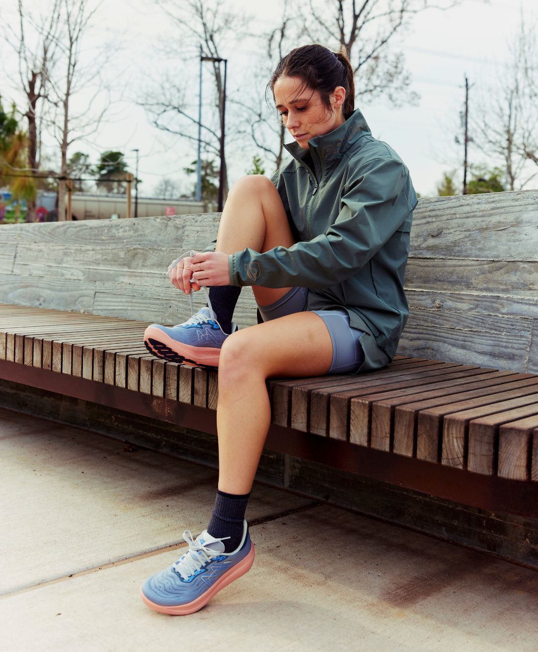 Female runner lacing up her KARHU Ikoni 3.0 running shoes